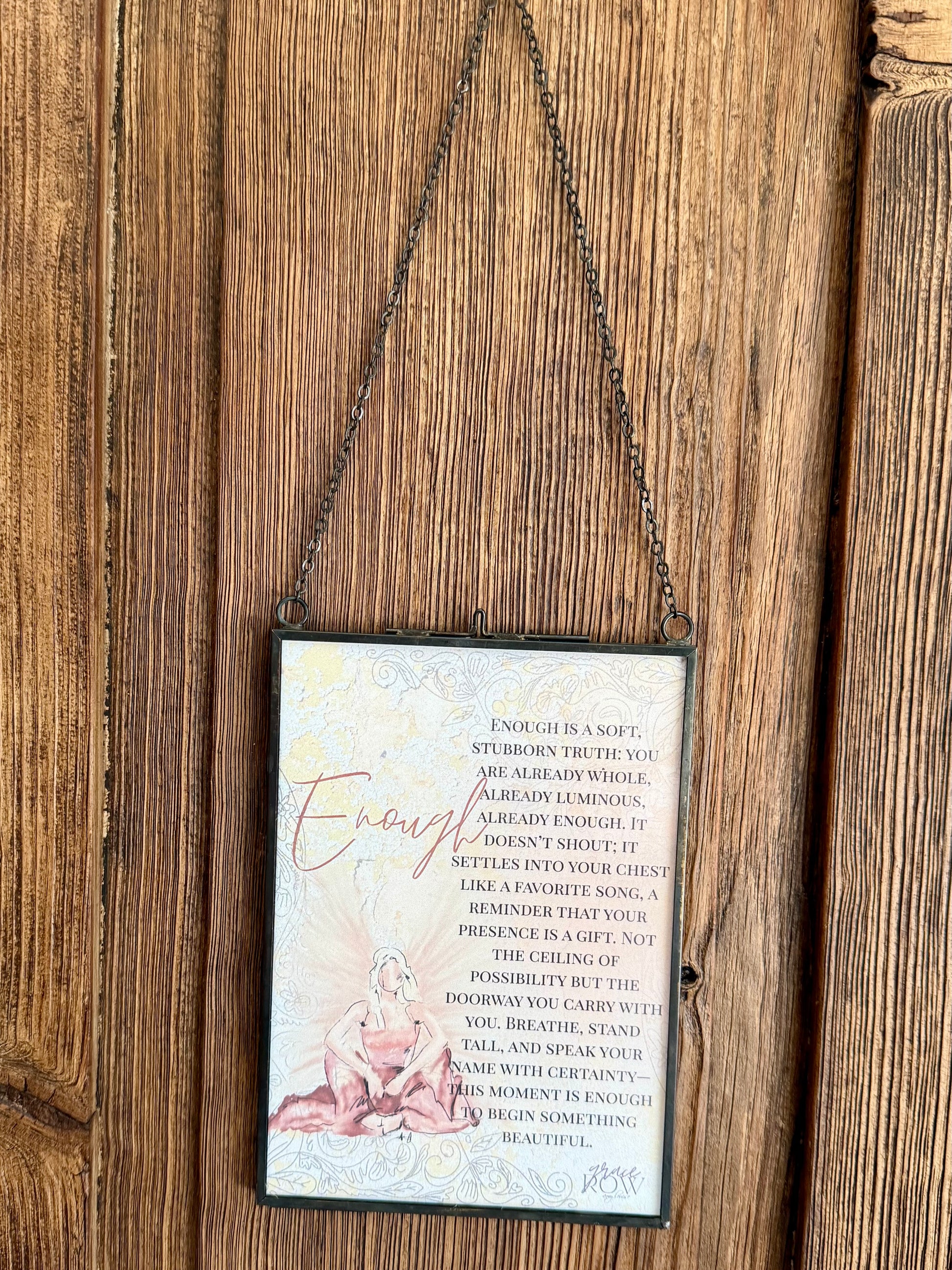 Decorative sign with text and illustration hanging on a wooden wall.