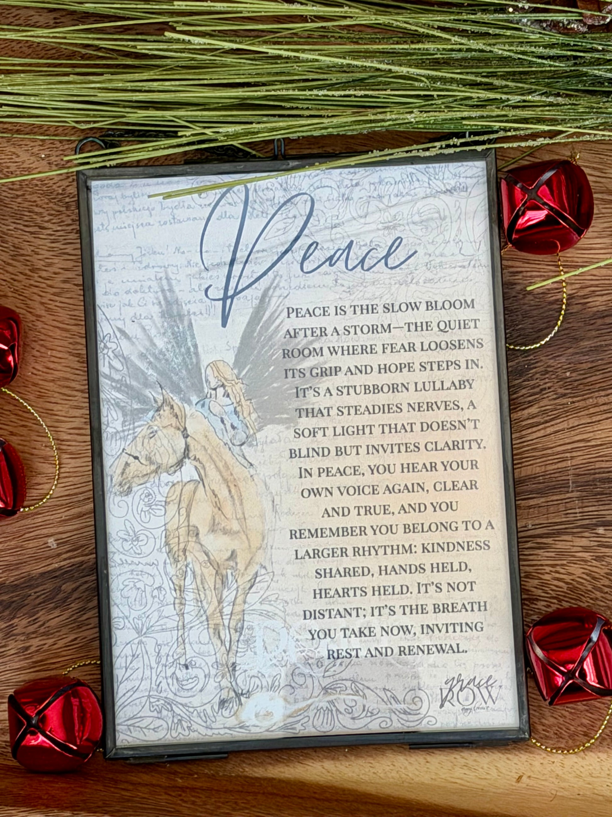 Decorative card with horse illustration and text on a wooden surface with red jingle bells.