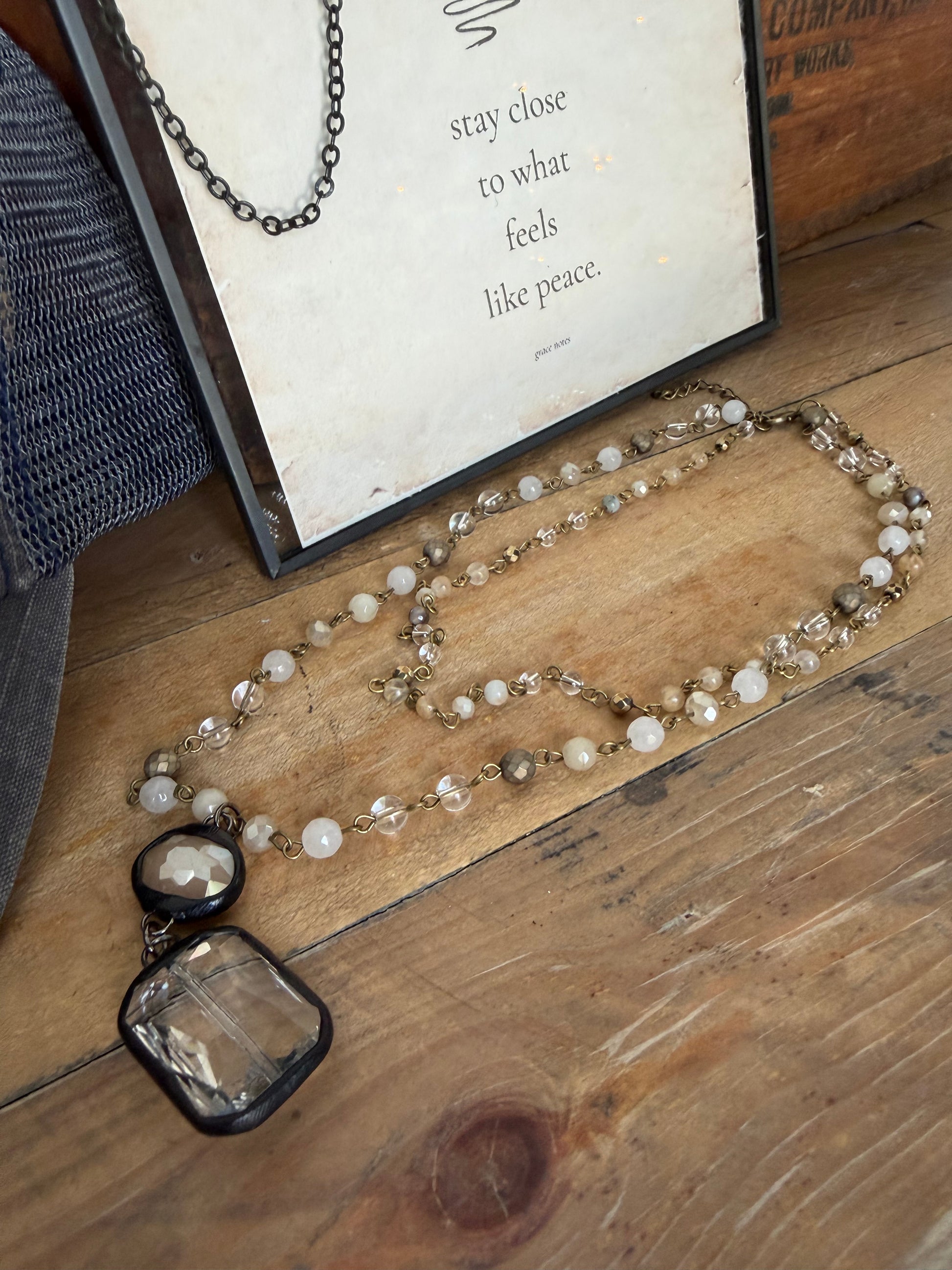 Necklace with beads on a wooden surface next to an open book