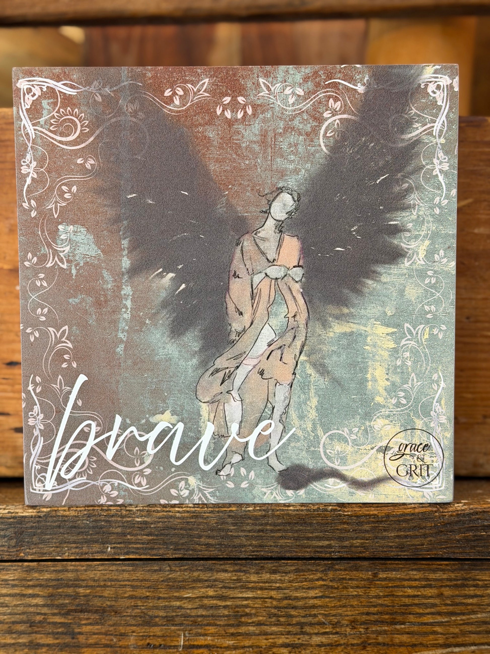 Decorative card with artistic design of a woman and text on a wooden surface