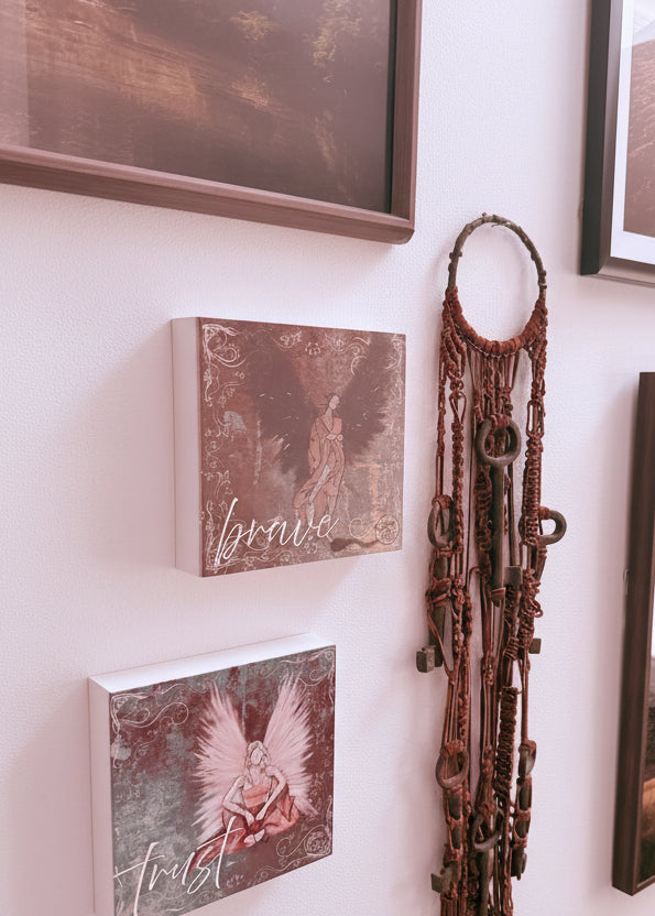 Decorative items including framed pictures and a decorative metal piece on a white surface.